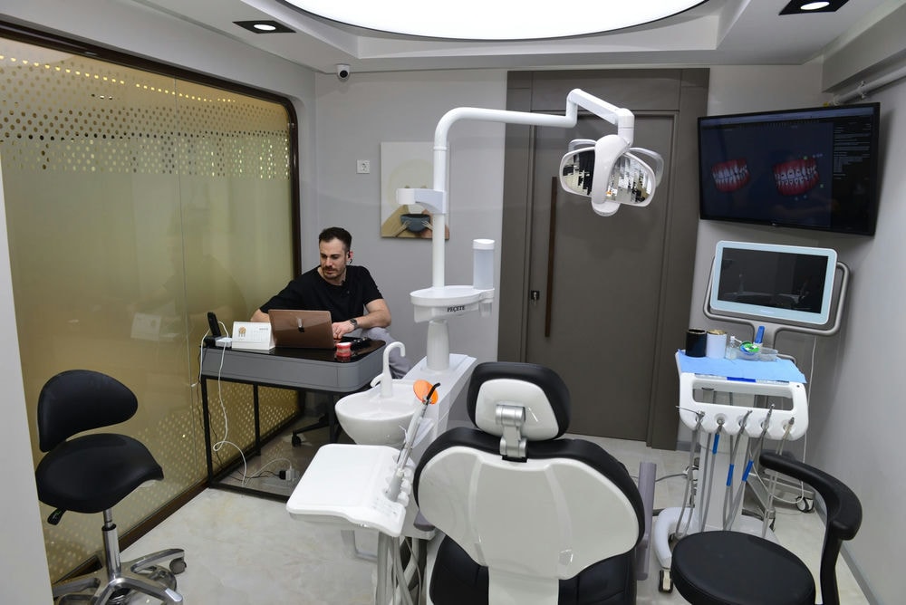 4K Dent klinik odası — beyaz dental ünite ve sıcak tavan aydınlatması